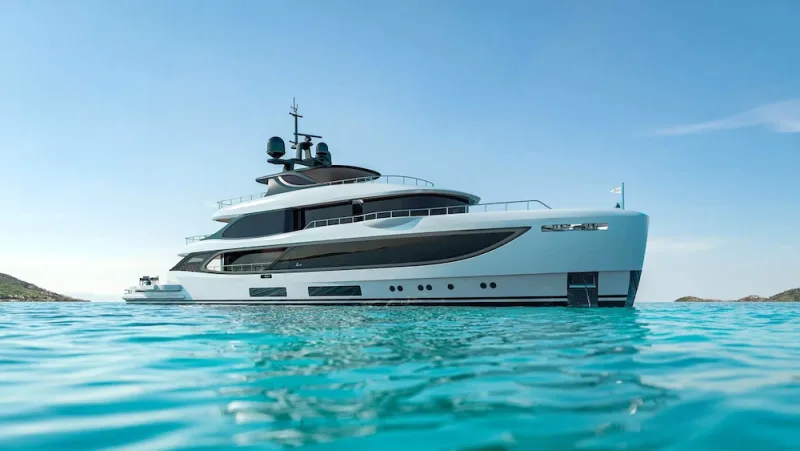 A displacement motor yacht at anchor in turquoise water